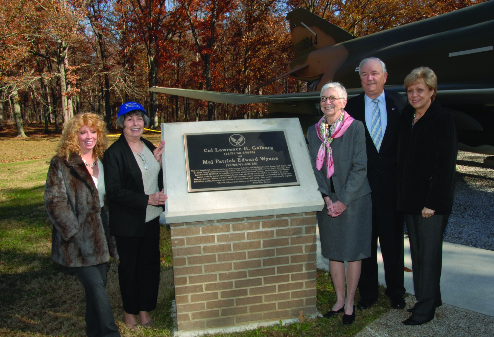 Col. Lawrence Golberg’s daughter Susan, left, and his widow Margaret, second from left, and Maj. Patrick Wynne’s widow, Nancy Matalon, center, brother Michael, then-Secretary of the Air Force Michael Wynne and sister-in-law Barbara pose for a photo alongside the plaque honoring the fallen Airmen during the Nov. 27, 2007, ceremony at Arnold Air Force Base to dedicate the F-4C Phantom II in memory of Golberg and Wynne. (U.S. Air Force photo by David Housch)
