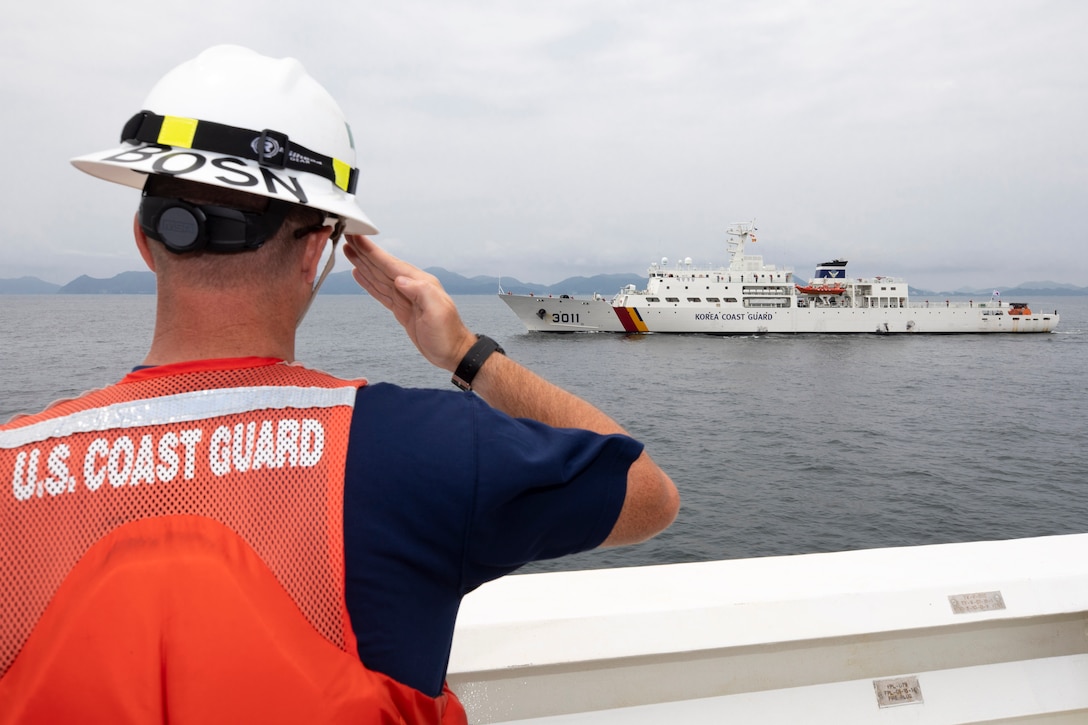 Chief Warrant Officer 2 Tim Kelley mans the rails of U.S. Coast Guard Cutter Munro (WMSL 755) and renders honors to Korea Coast Guard vessel KCG 3011 (Badaro) at the conclusion of an at sea engagement in the Tsushima Strait Aug. 16, 2023. Munro deployed to the Western Pacific under U.S. Navy 7th Fleet command to serve as a non-escalatory asset for the promotion of a rules-based order in the maritime domain by engaging with partner nations and allies in the region. (U.S. Navy photo by Chief Petty Officer Brett Cote)