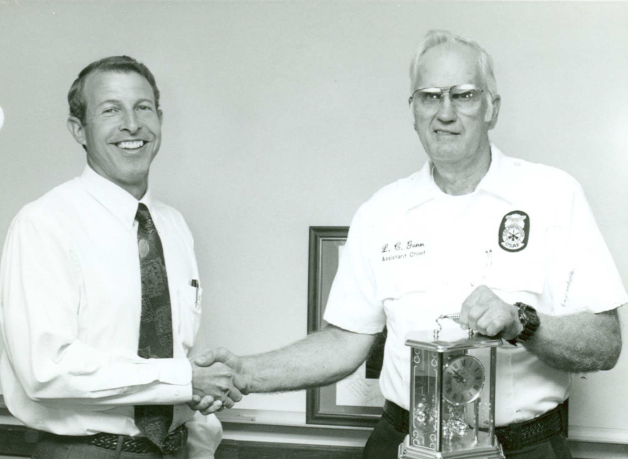 In 1996, L.C. Gunn, right, receives a retirement clock from Mike Cunningham, then manager of base services operations for Arnold Engineering Development Complex at Arnold Air Force Base, Tenn. (U.S. Air Force Photo)