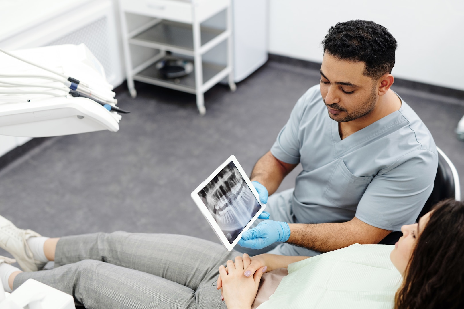 Dentist shows patient X-ray on tablet