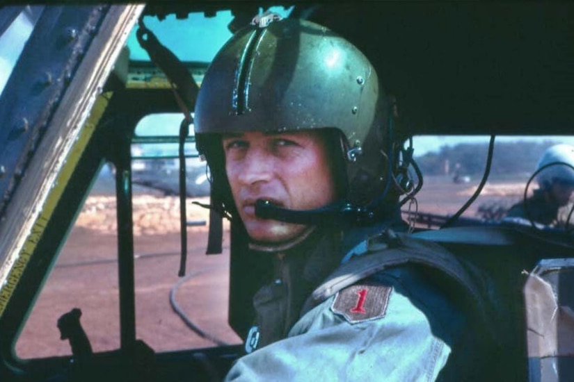 A pilot in an aircraft cockpit poses for a photo.