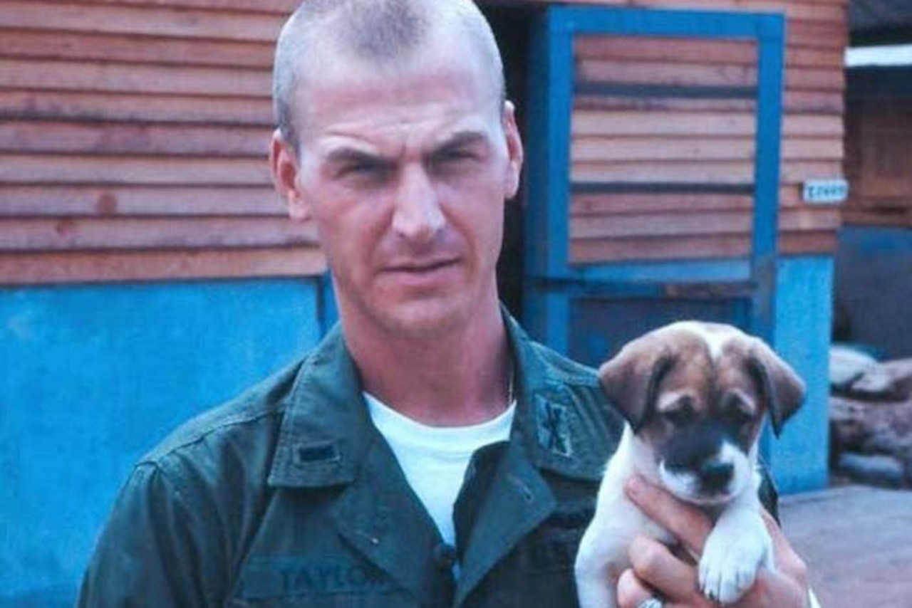 A soldier holds a puppy.