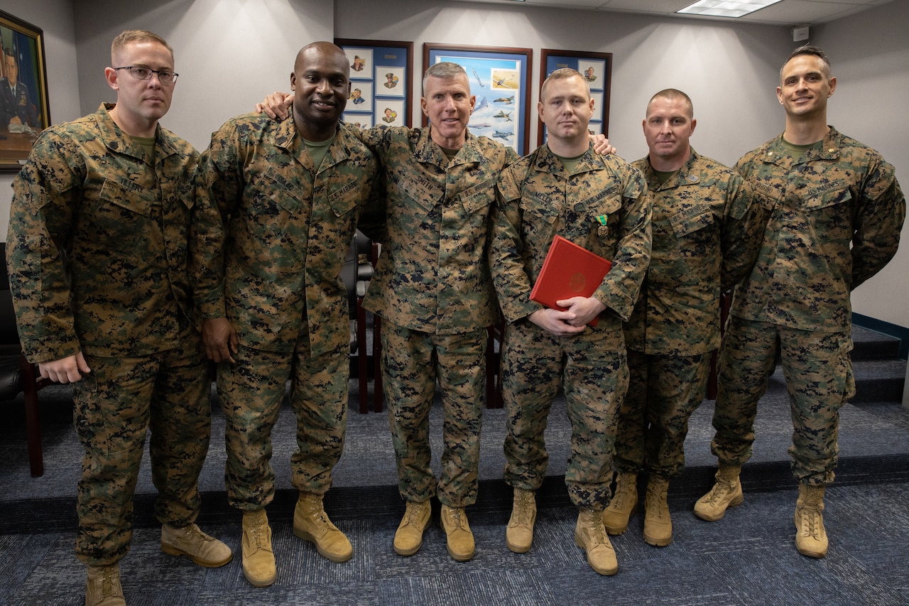 Six men in uniform stand together for a photo.
