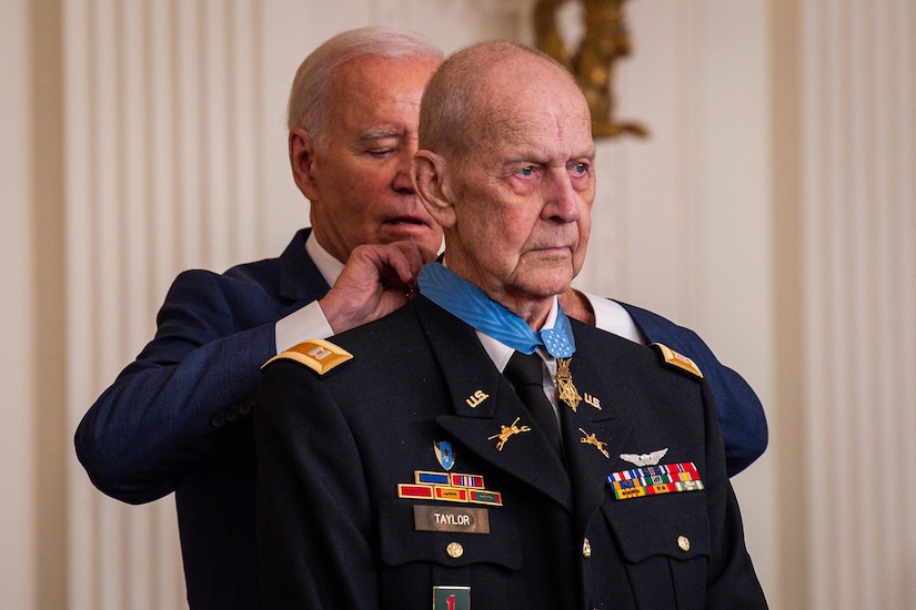 President Joe Biden places the Medal of Honor around the collar of former Army Capt. Larry L. Taylor.