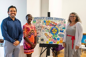 Graphic illustrator Tiiwon Siaway (center) displays her work at the Air Education and Training Command Learning Symposium, Aug. 24, 2023. Standing with Siaway are Marcus Carrion (left), AETC symposium facilitator and co-chair, and Dr. Wendy Walsh (right), AETC chief learning officer. The symposium was held Aug. 22-24 at Air University, Maxwell Air Force Base, Ala., with the last day being held at the Kress building in downtown Montgomery, Ala. The symposium provided the more than 60 learning professionals from across the Department of the Air Force a ‘sharing space’ to learn from and hear about each other’s stories and successes, with the goal of transforming the way Airmen and Guardians learn. Several graphic illustrators at the symposium helped capture the dialogue amongst attendees as another medium to tell their stories. (U.S. Air Force photos by Sean Ross)