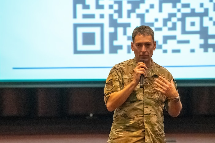 U.S. Air Force Col. Andrew Roddan, 374th Airlift Wing commander, speaks to an audience of Yokota community members during a town hall to discuss the transition to MHS GENESIS, the new electronic health record for the Military Health System (MHS), at Yokota Air Base, Japan, Aug. 31, 2023.