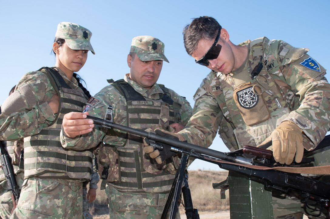 Soldiers conduct machine gun clearing procedures during a training exercise.