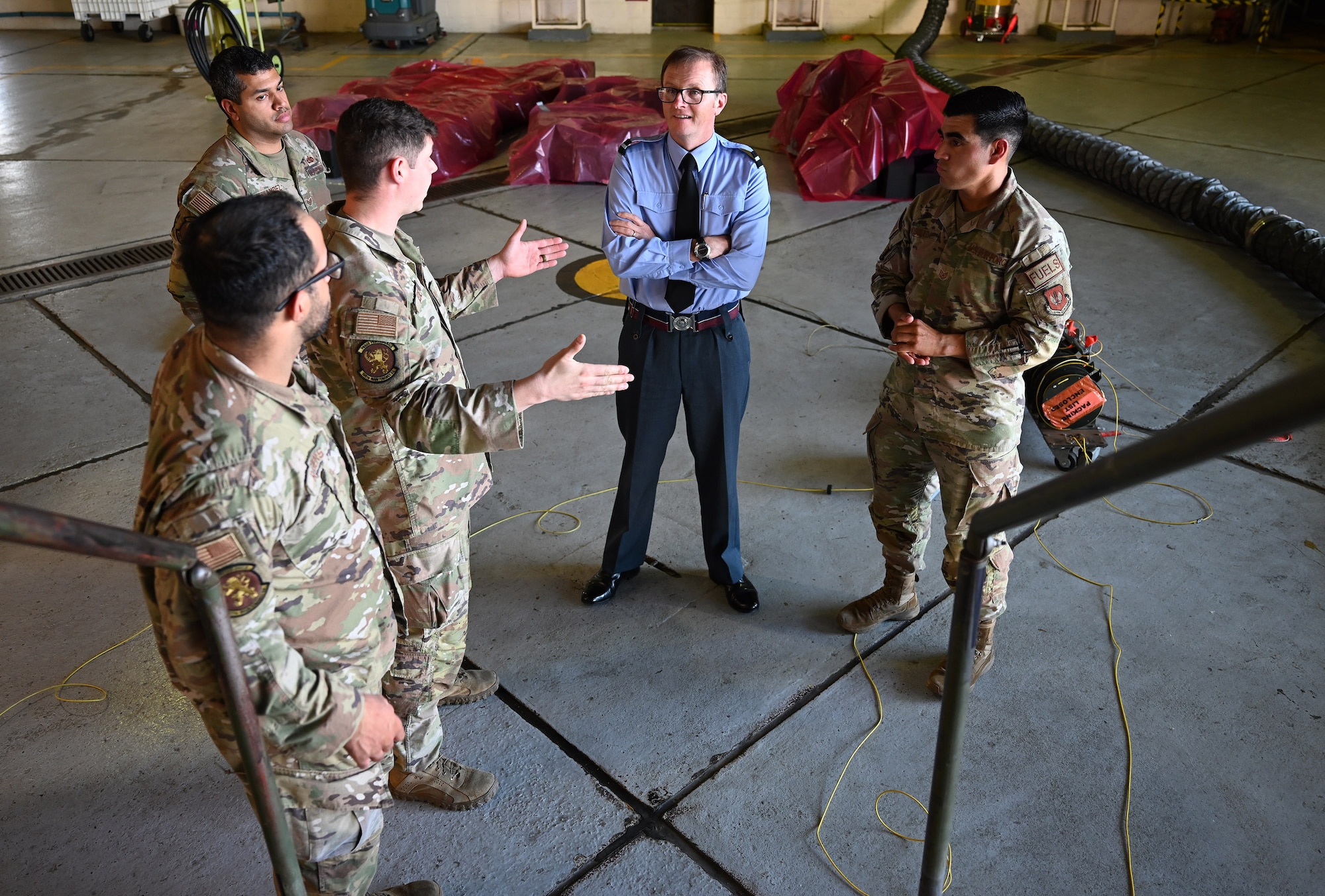 U.S. Air Force Airmen from the 100th Maintenance Squadron fuel cell repair shop, share the importance of their role with Air Commodore Simon Strasdin, Royal Air Force Intelligence, Surveillance, Target Acquisition and Reconnaissance force commander, during a visit at RAF Mildenhall, England, Aug. 23, 2023. Strasdin was here to strengthen United Kingdom-US relationships and thank 100th ARW, 95th Reconnaissance Squadron and 488th Intelligence Squadron Airmen for their hard work and cooperation in the joint partnership program between the RAF and U.S. Air Force reconnaissance aircraft. (U.S. Air Force photo by Karen Abeyasekere)