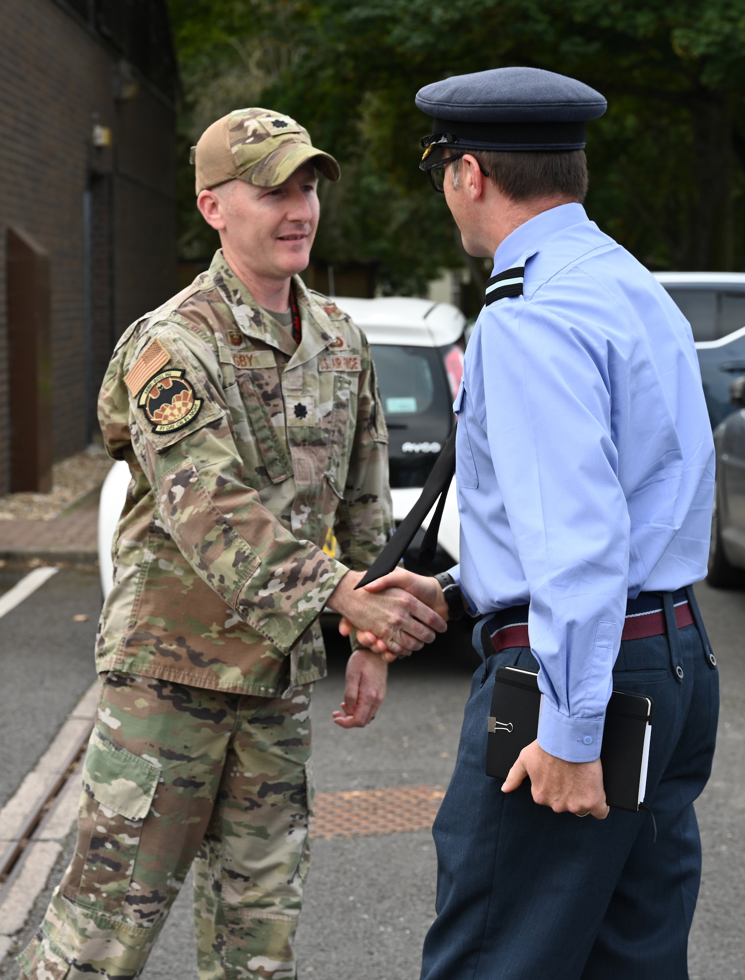 Air Commodore Simon Strasdin, right, Royal Air Force Intelligence, Surveillance, Target Acquisition and Reconnaissance force commander, based at RAF Waddington, is greeted by Lt. Col. Bradley Higby, 488th Intelligence Squadron commander, during a visit to RAF Mildenhall, England, Aug. 23, 2023. Strasdin was here to strengthen United Kingdom-US relationships and thank 100th ARW, 95th Reconnaissance Squadron and 488th IS Airmen for their hard work and cooperation in the joint partnership program between the RAF and U.S. Air Force reconnaissance aircraft. (U.S. Air Force photo by Karen Abeyasekere)