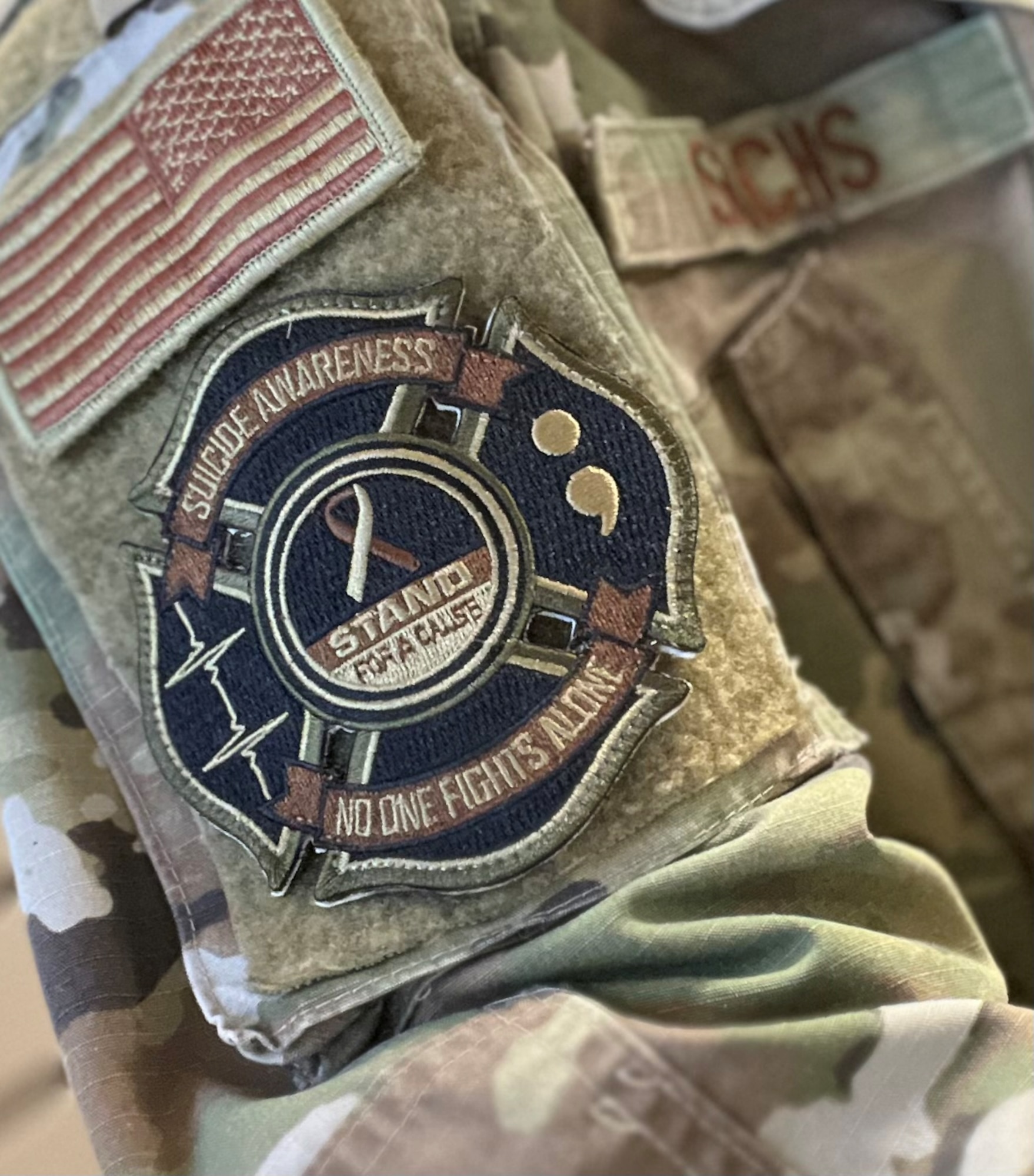 Photo of black, green and brown patch that reads, "Suicide awareness, no one fights alone."