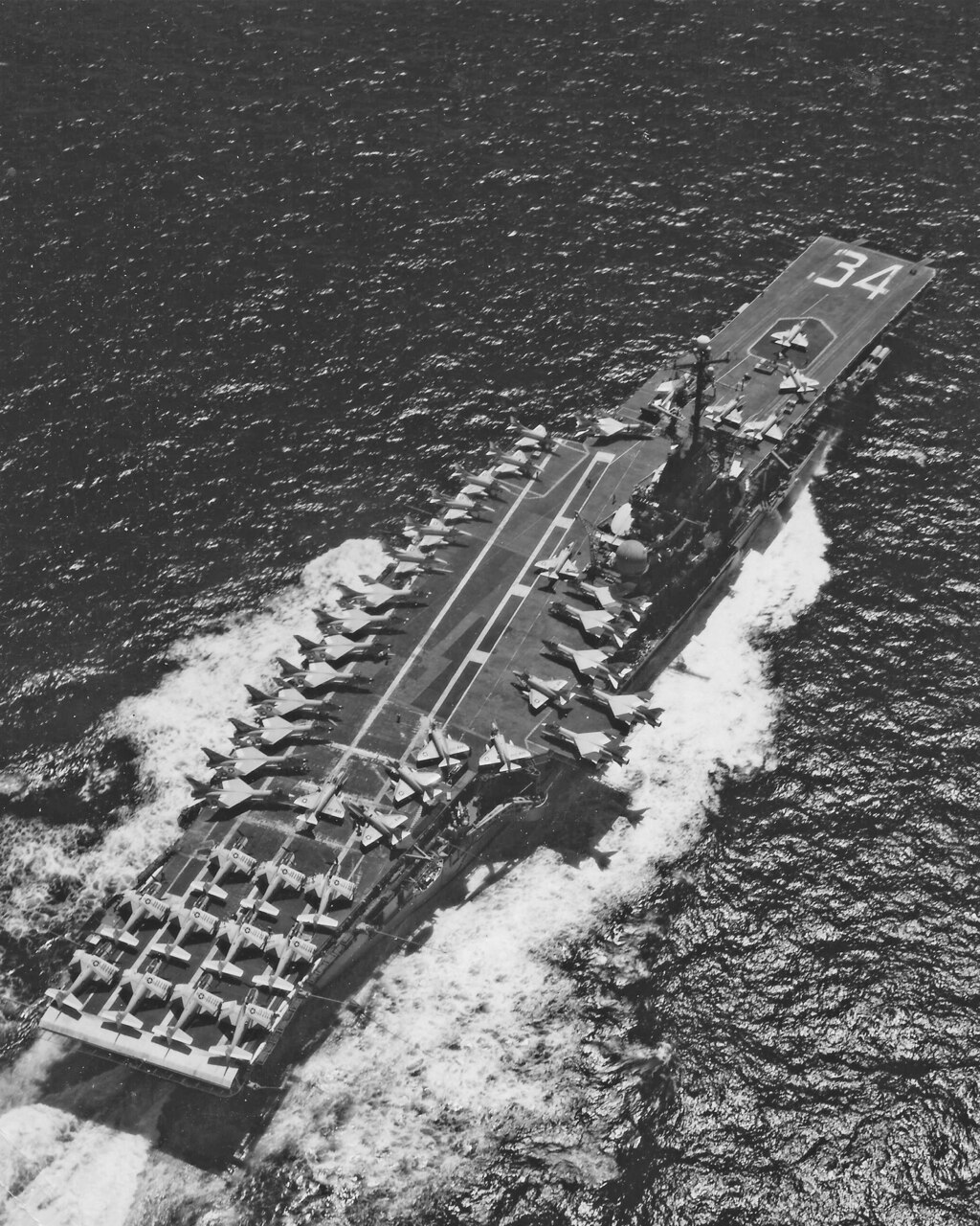 USS Oriskany (CVA 34) saw much action during Vietnam. In 1967, with CVW-16 aboard, the ship cruises the South China Sea, her flight deck is crowded with A-1 Skyraiders. A-4 Skyhawks and F-8 Crusaders. Note the lone Skyhawk on the carrier’s bow elevator, aft of the hull number. During this deployment, 39 aircraft were lost, while VF-162’s Lt. Richard Wyman used AIM-9D Sidewinders to down a MiG-17 in December in a swirling dogfight involving A-4s, other F-8s and very aggressive MiG pilots.
