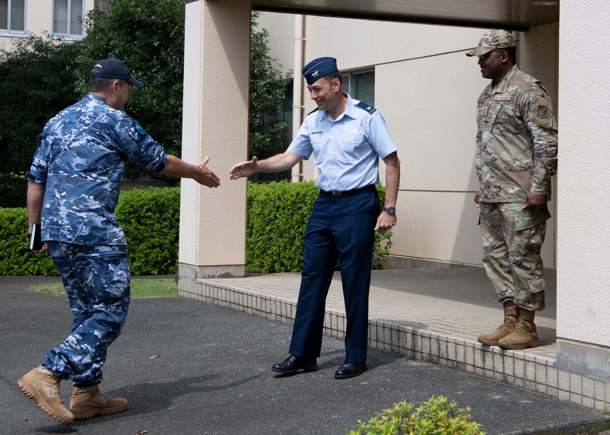 A military man shakes hand with another military man.