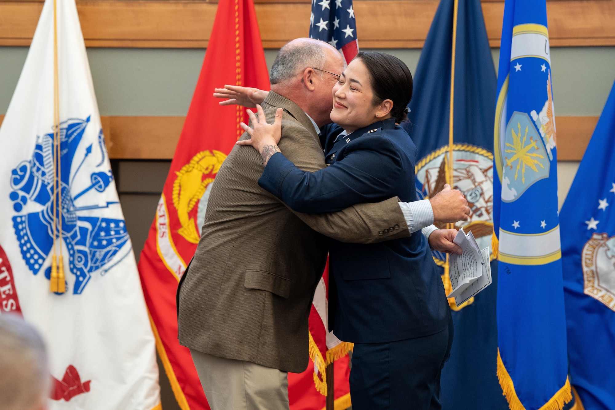 A woman embraces a man in a hug.