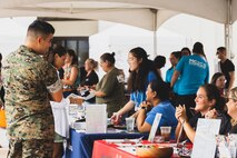A U.S. Marine speaks with representatives of Special Olympics Hawaii, an organization with the goal of providing year-round sports training and athletic competition in a variety of Olympic-type sports for children and adults with intellectual disabilities, during a volunteer fair at the Mokapu Mall, Marine Corps Base Hawaii, Aug. 25, 2023. The volunteer fair was held to showcase the base’s volunteer efforts and partnerships with external community organizations, fostering collaboration and community engagement. (U.S. Marine Corps photo by Cpl. Brandon Aultman)