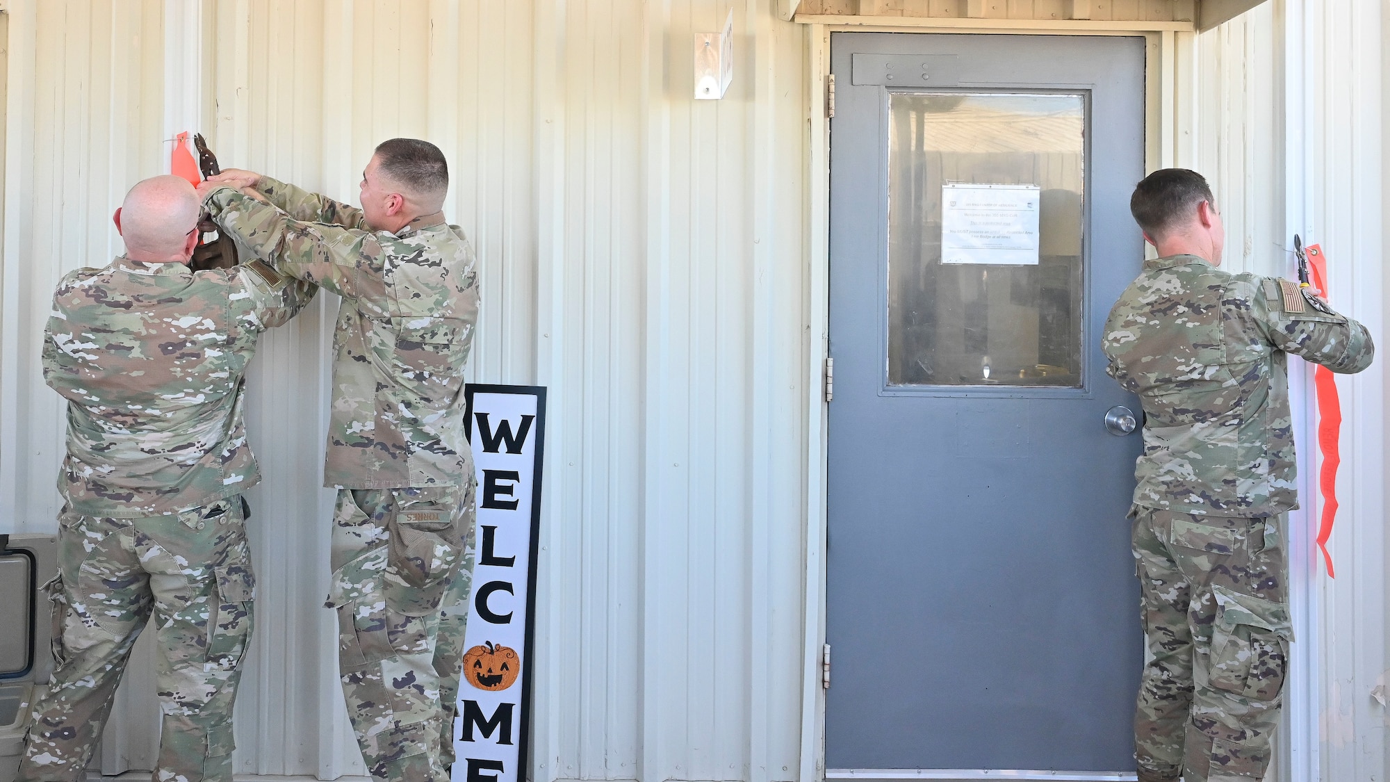 Pictured above are three Airmen cutting a ribbon at a grand opening.