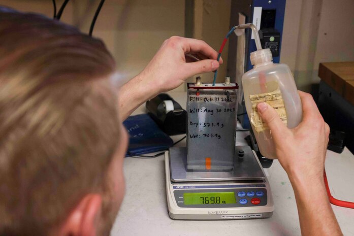 U.S. Air Force Senior Airman Maxwell Karline, 9th Maintenance Squadron electrical and environmental systems craftsmen, adjusts the “wet” weight of a silver zinc cell Aug. 11, 2023, at Beale Air Force Base, California.