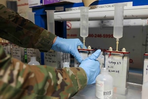 U.S. Air Force Senior Airman Maxwell Karline, 9th Maintenance Squadron electrical and environmental systems craftsmen, squeezes trapped air from a battery cell to soak interior plates prior to initially charging the battery Aug. 16, 2023, at Beale Air Force Base, California.