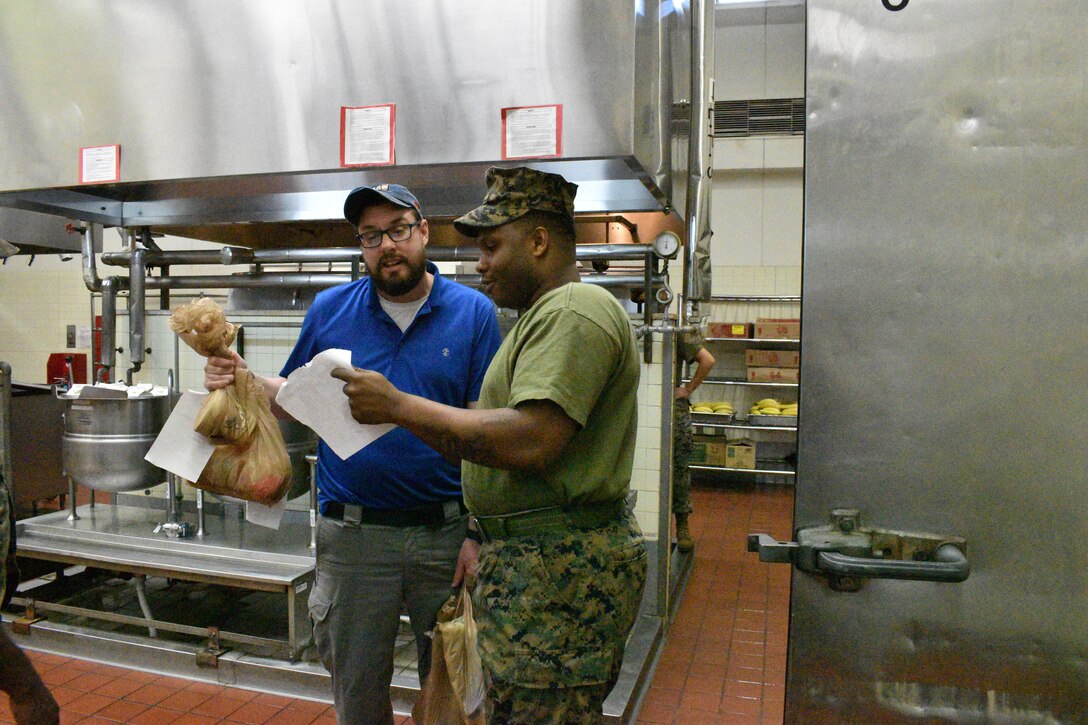 Customer, Benjamin Rush examines his receipt with Sgt Tyreek Braithwaite.