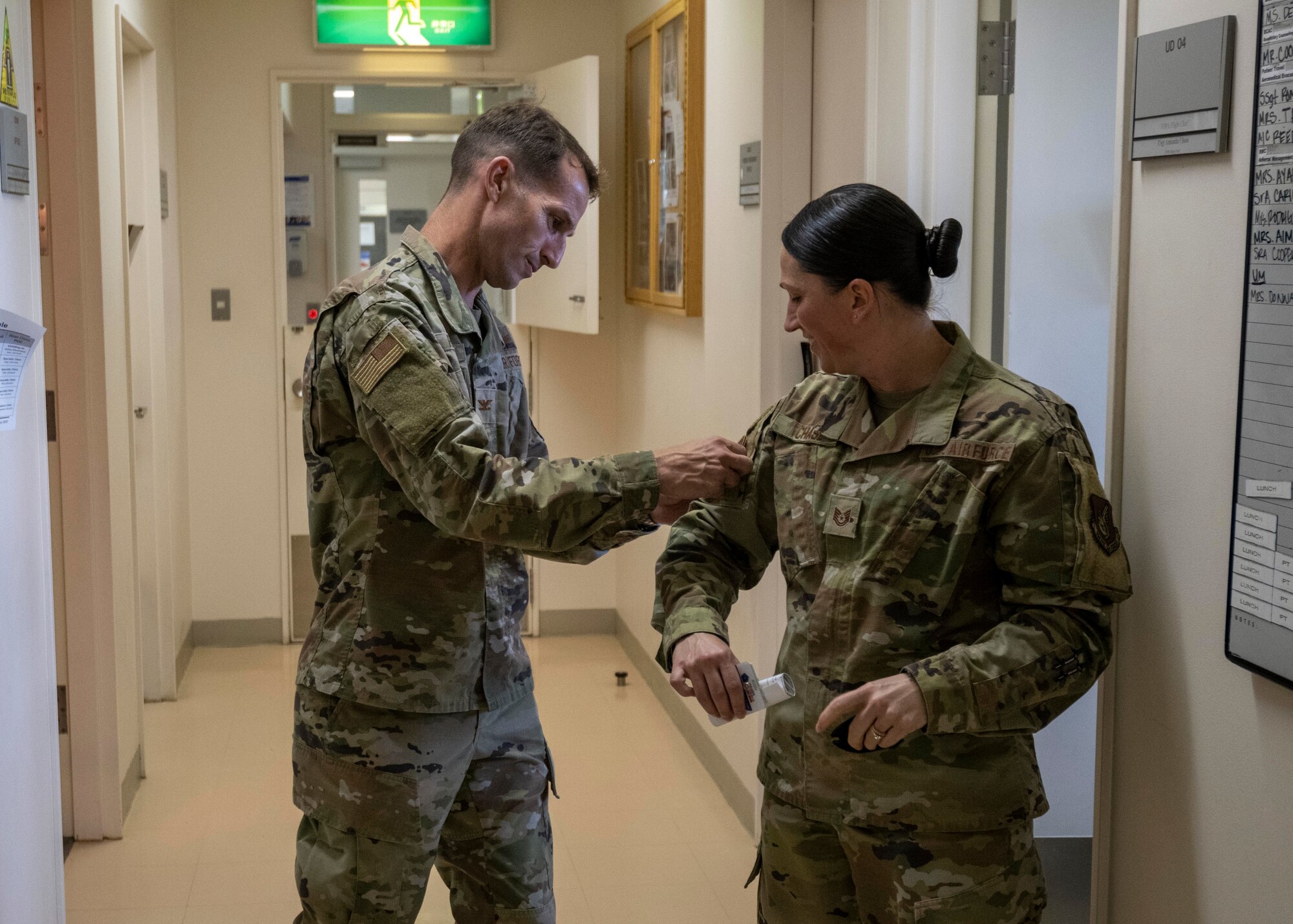 U.S. Air Force Col. Michael Richard, 35th Fighter Wing commander, exchanges patches with Tech. Sgt. Amanda Chase, TRICARE Operations and Patient Administration flight chief, during a Wild Weasel Walk-through at Misawa Air Base, Japan.