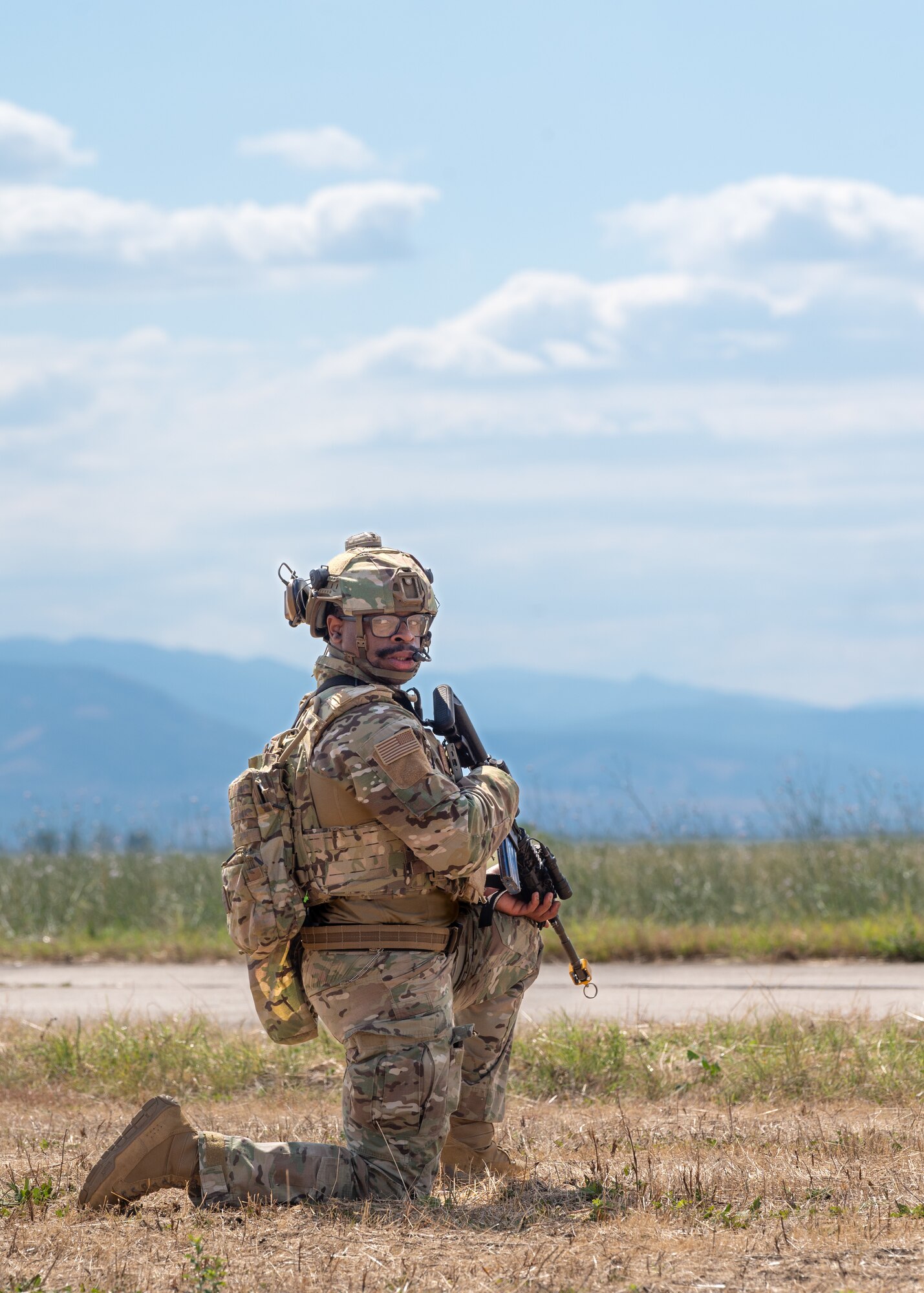 A man kneels with a gun