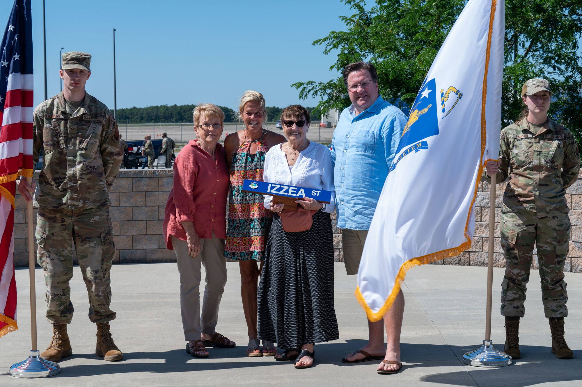 Photo of a ceremony honoring a fallen Airman, his family in attendance.