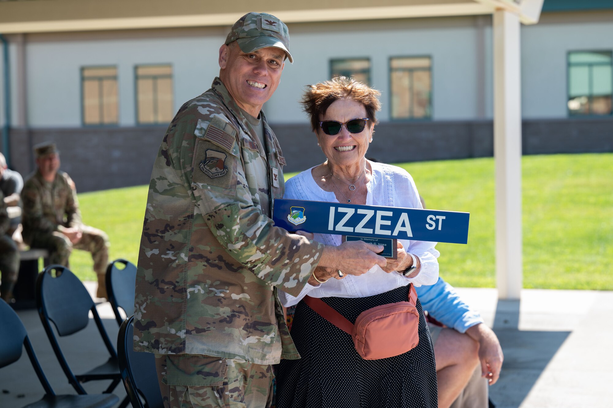 Photo of a ceremony honoring a fallen Airman, his family in attendance.