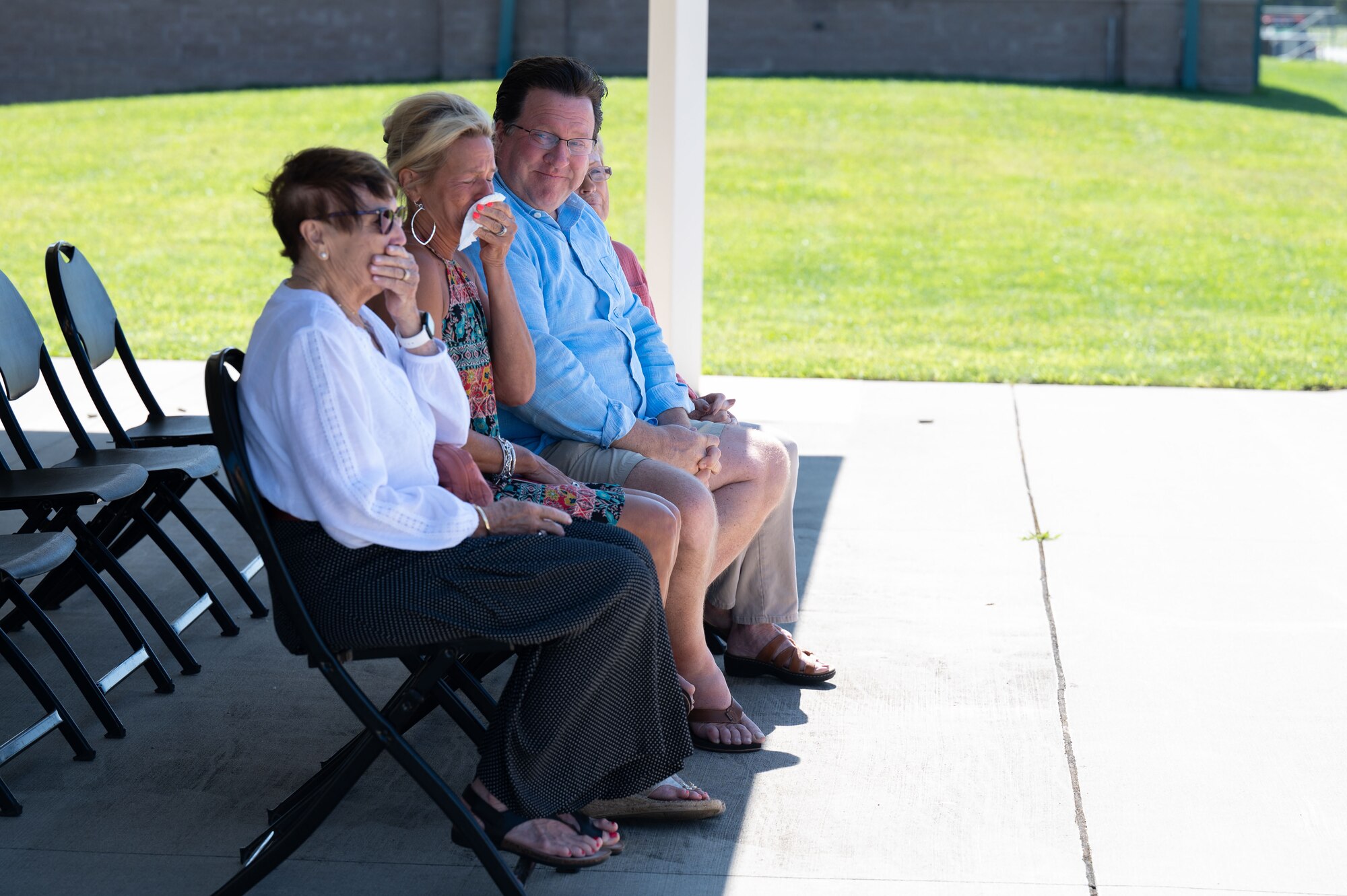 Photo of a ceremony honoring a fallen Airman, his family in attendance.