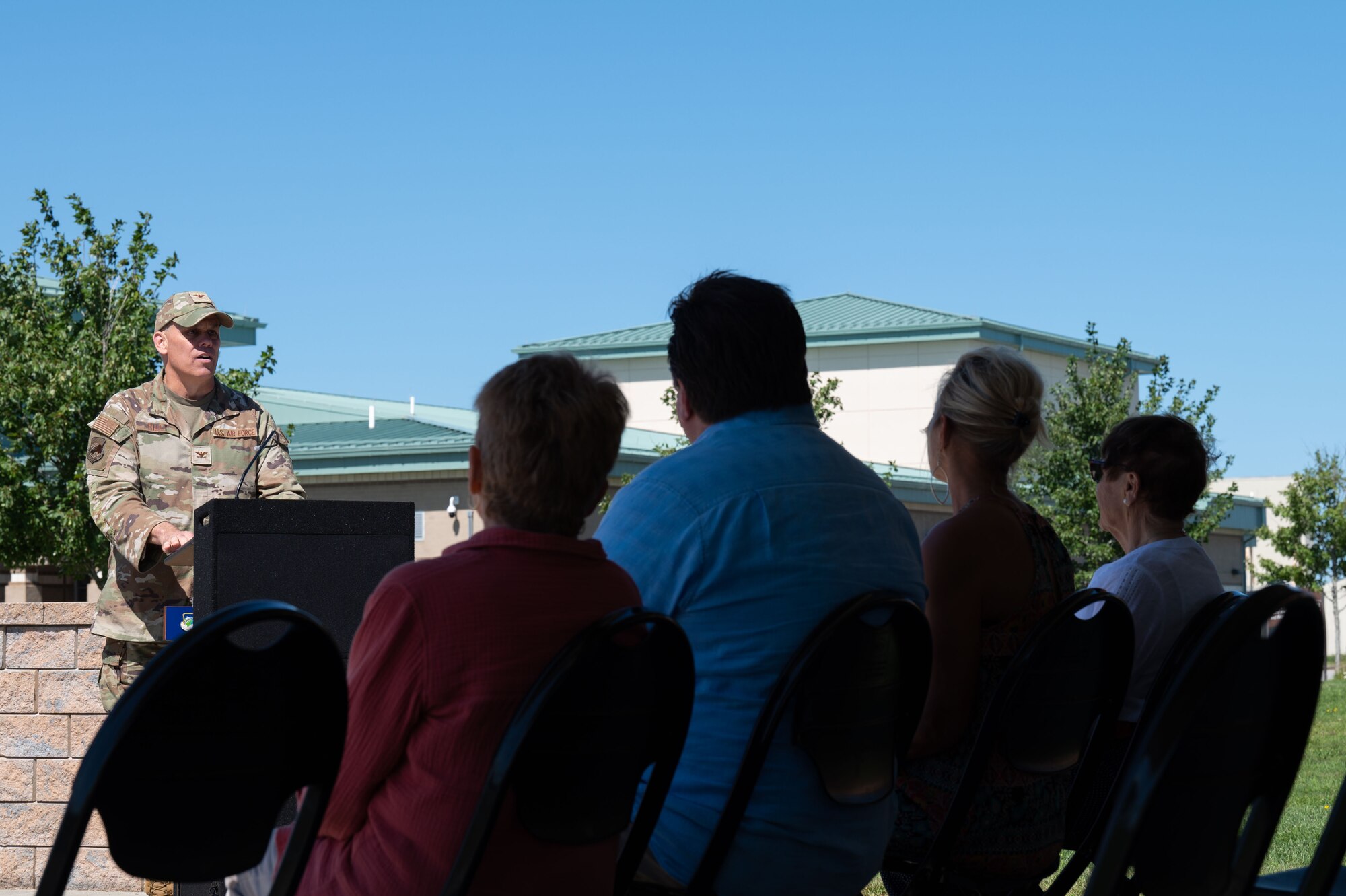 Photo of a ceremony honoring a fallen Airman, his family in attendance.