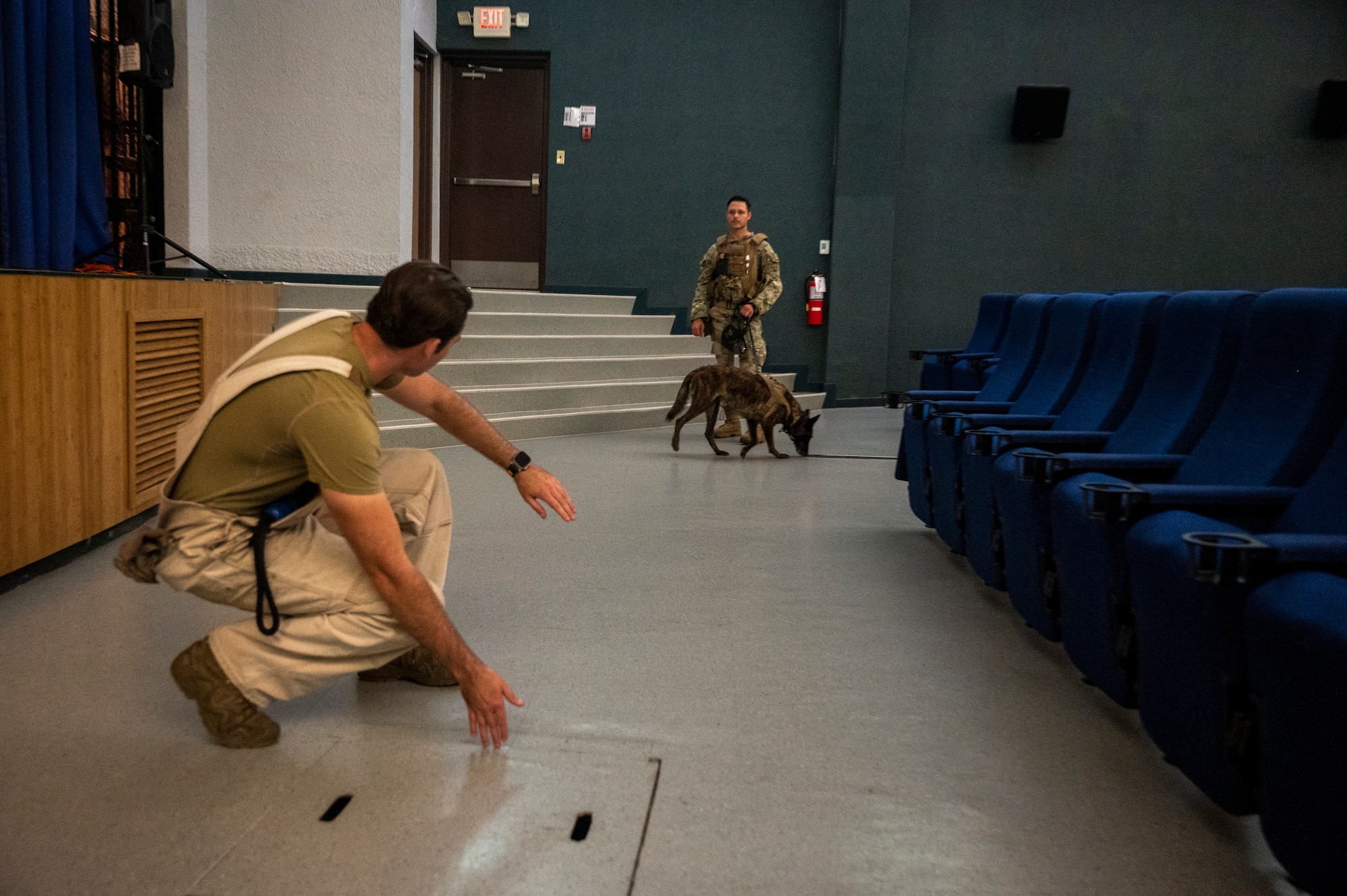 U.S. Air Force Staff Sgt. Charles Gaines, left, 51st Security Forces Squadron military working dog trainer, gives feedback to Senior Airman Tommi Jones, 51st SFS MWD handler, during a routine detection training at Osan Air Base, Republic of Korea, Sept. 6, 2023. MWD trainers are responsible for ensuring MWD handlers and MWDs are qualified and able to execute the mission and defend the base. (U.S. Air Force photo by Senior Airman Aaron Edwards)