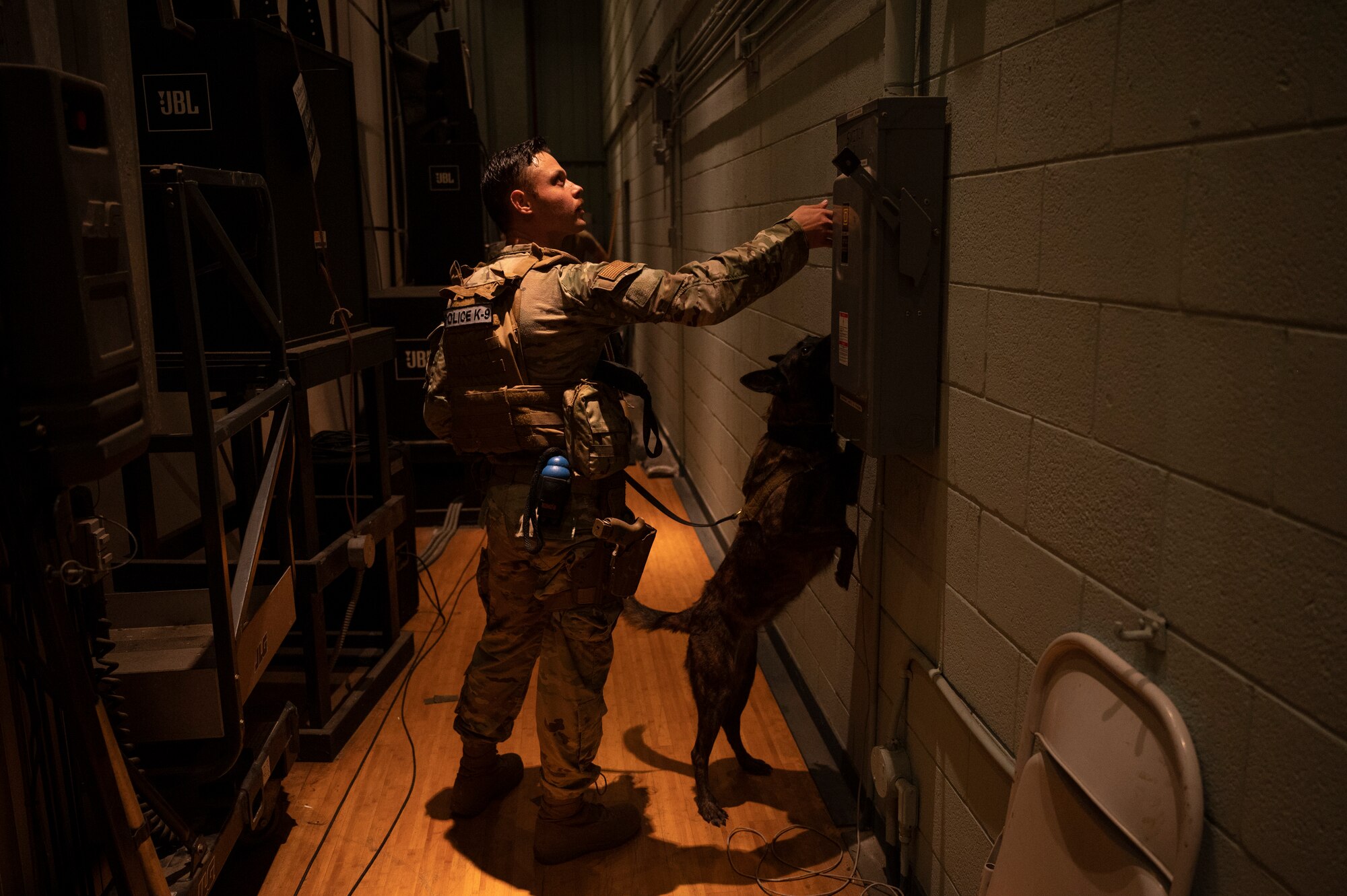 U.S. Air Force Senior Airman Tommi Jones, 51st Security Forces Squadron military working dog handler, gestures to MWD Cora, during a routine detection training at Osan Air Base, Republic of Korea, Sept. 6, 2023. During detection missions, MWDs will search for items by themselves, but handlers are trained to assist their partners with specific commands and gestures to ensure all necessary items in the search are found. (U.S. Air Force photo by Senior Airman Aaron Edwards)