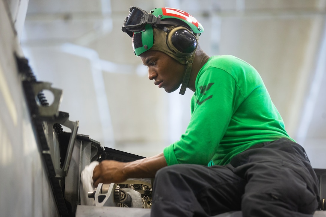 A sailor conducts routine maintenance on an F/A-18E Super Hornet.