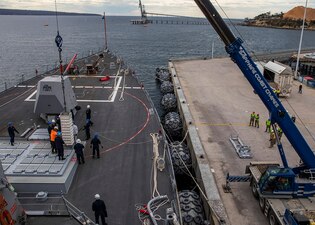 Sailors aboard USS Rafael Peralta (DDG 115) load an SM-2 missile container at the Port of Eden, Australia.