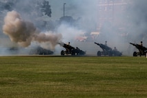 Field Artillery guns fire during a ceremony.