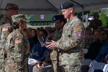 Two soldiers stand to accept gifts on behalf of the command.
