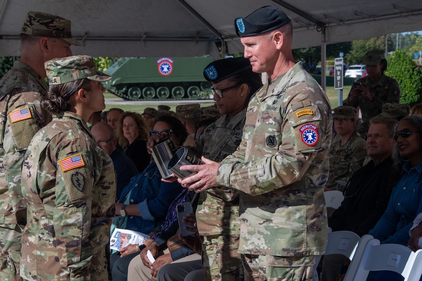 Two soldiers stand to accept gifts on behalf of the command.