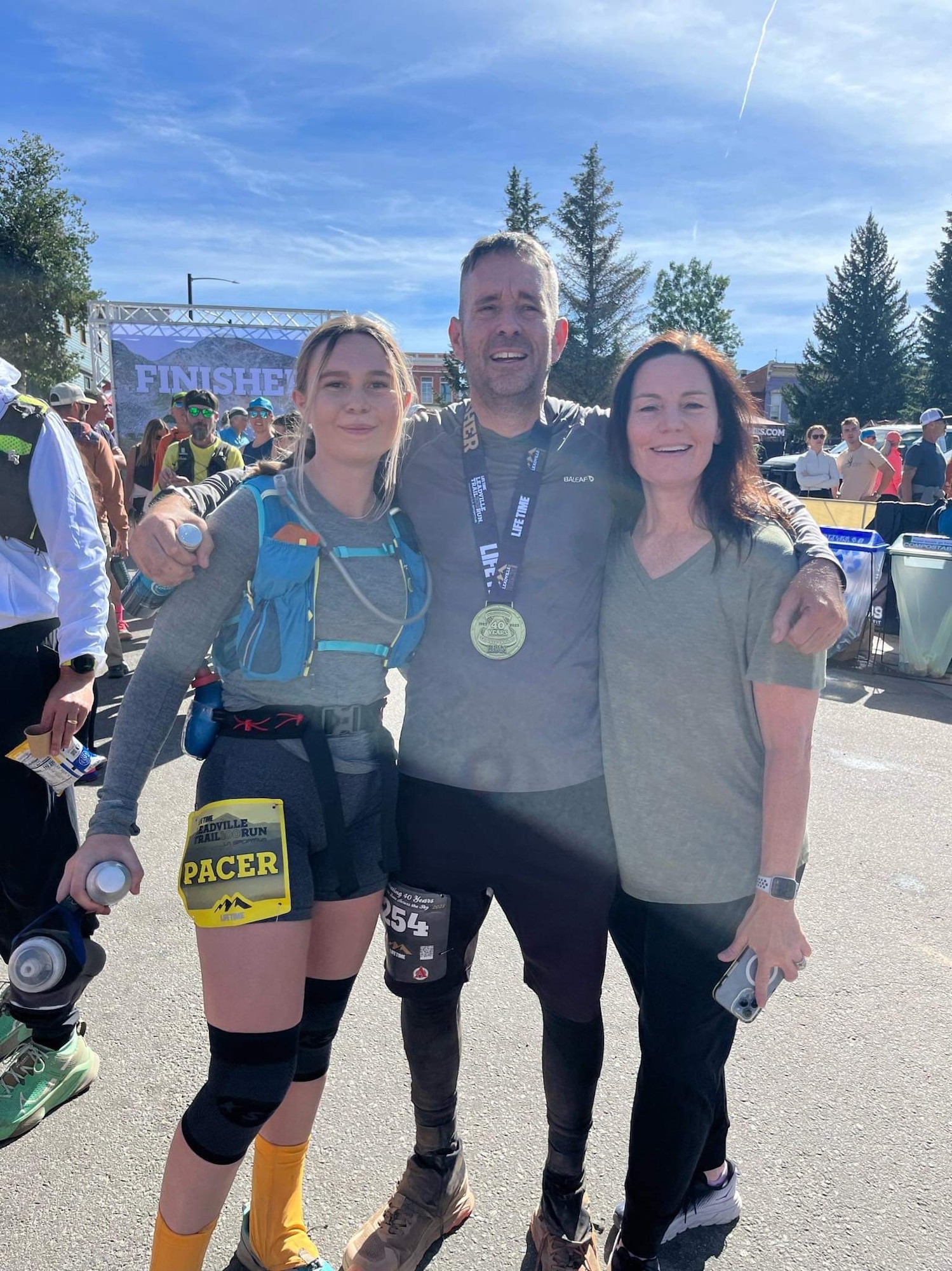 Patrick Buzzard, 4th Test and Evaluation Squadron, center, poses for a photo with his daughter, Hailey Buzzard, left, and his wife, Christine Buzzard, after completing the Leadville Trail 100 Run near Leadville, Colorado, Aug. 20, 2023. The Leadville Trail 100 Run is an ultramarathon held annually on rugged trails and dirt roads through the heart of the Rocky Mountains. The course is a 50-mile out-and-back dogleg run primarily on the Colorado Trail, starting at 10,200 feet. The centerpiece of the course is the climb up to Hope Pass at 12,620 feet, encountered on both the outbound trek and on the return. Buzzard finished the 100-mile course in 29 hours, 48 minutes, and 57 seconds, just beating the 30-hour time limit. (Courtesy photo)