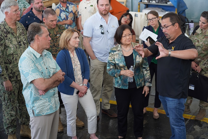 A person gestures as others watch.