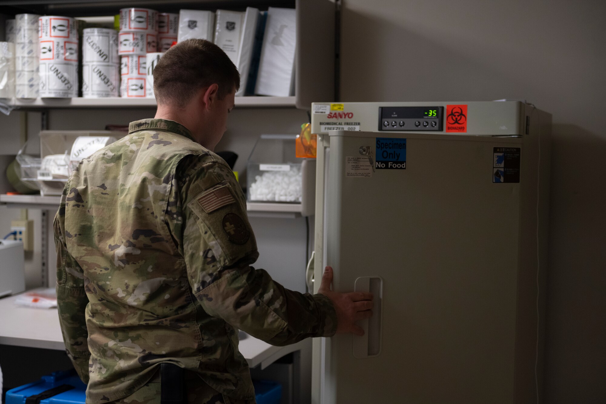 An Airman opens a refrigerated door.