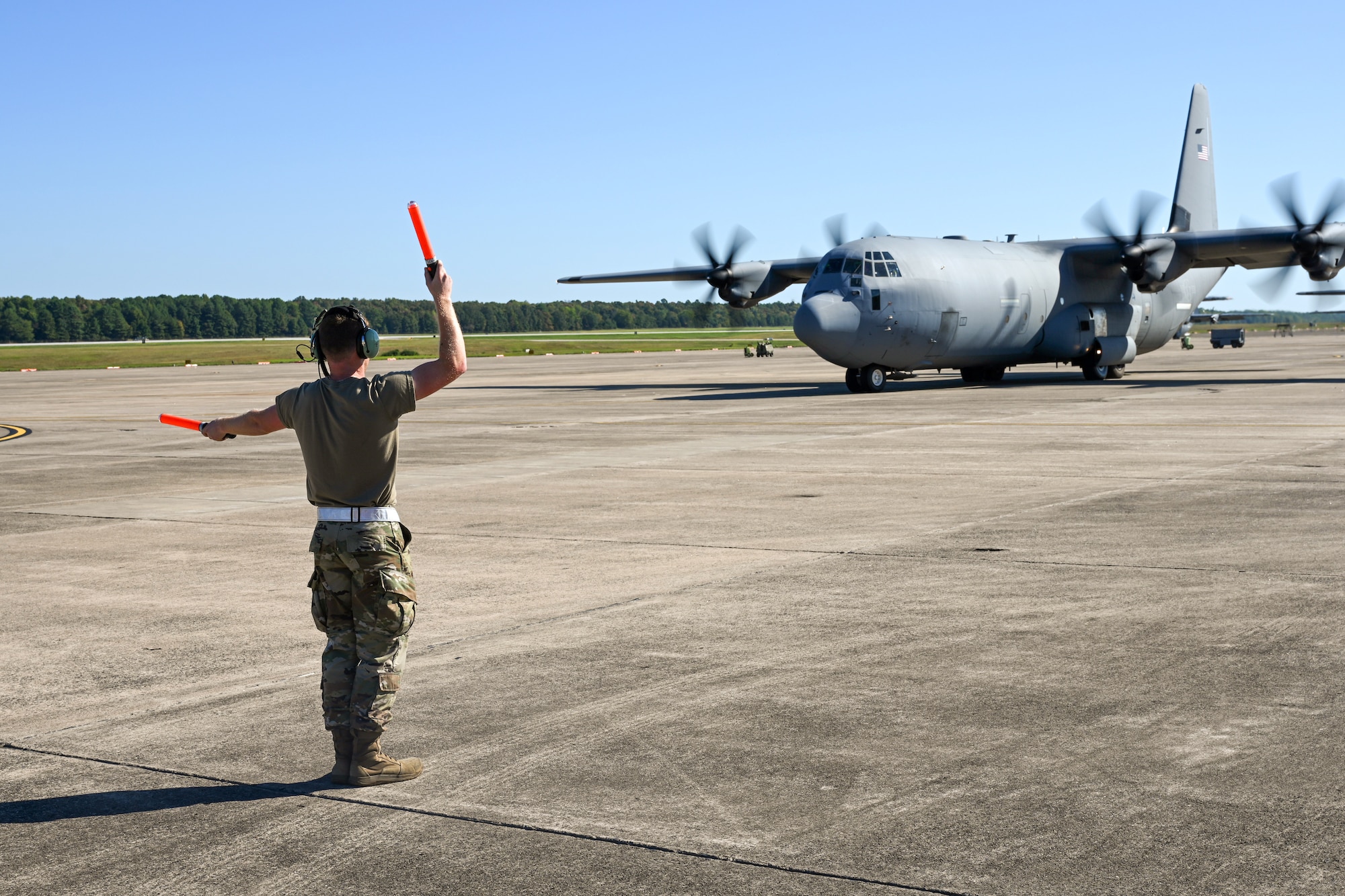 A 19th Airlift Wing crew chief marshals a C-130J Super Hercules before takeoff