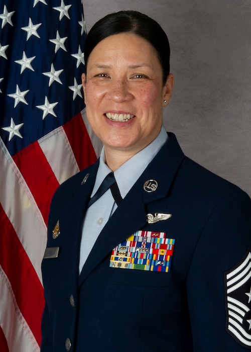a woman in a blue military uniform in front of a flag