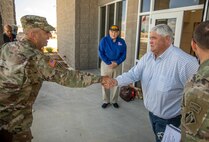 two people are shaking hands as other look on