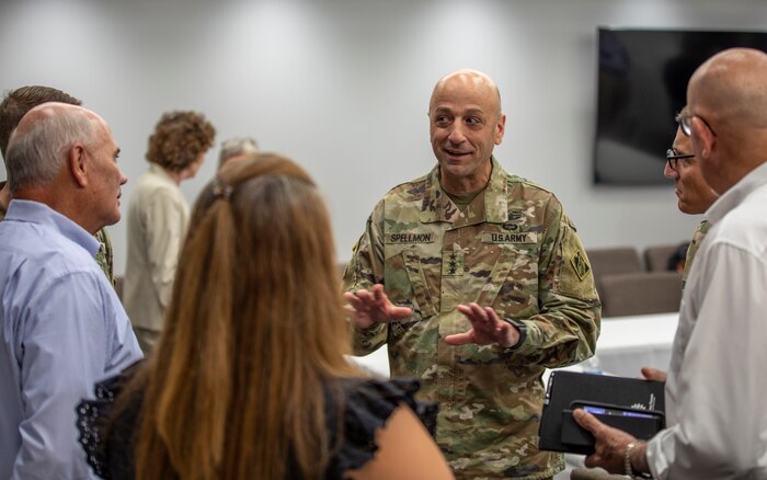people are standing in a small group inside, talking