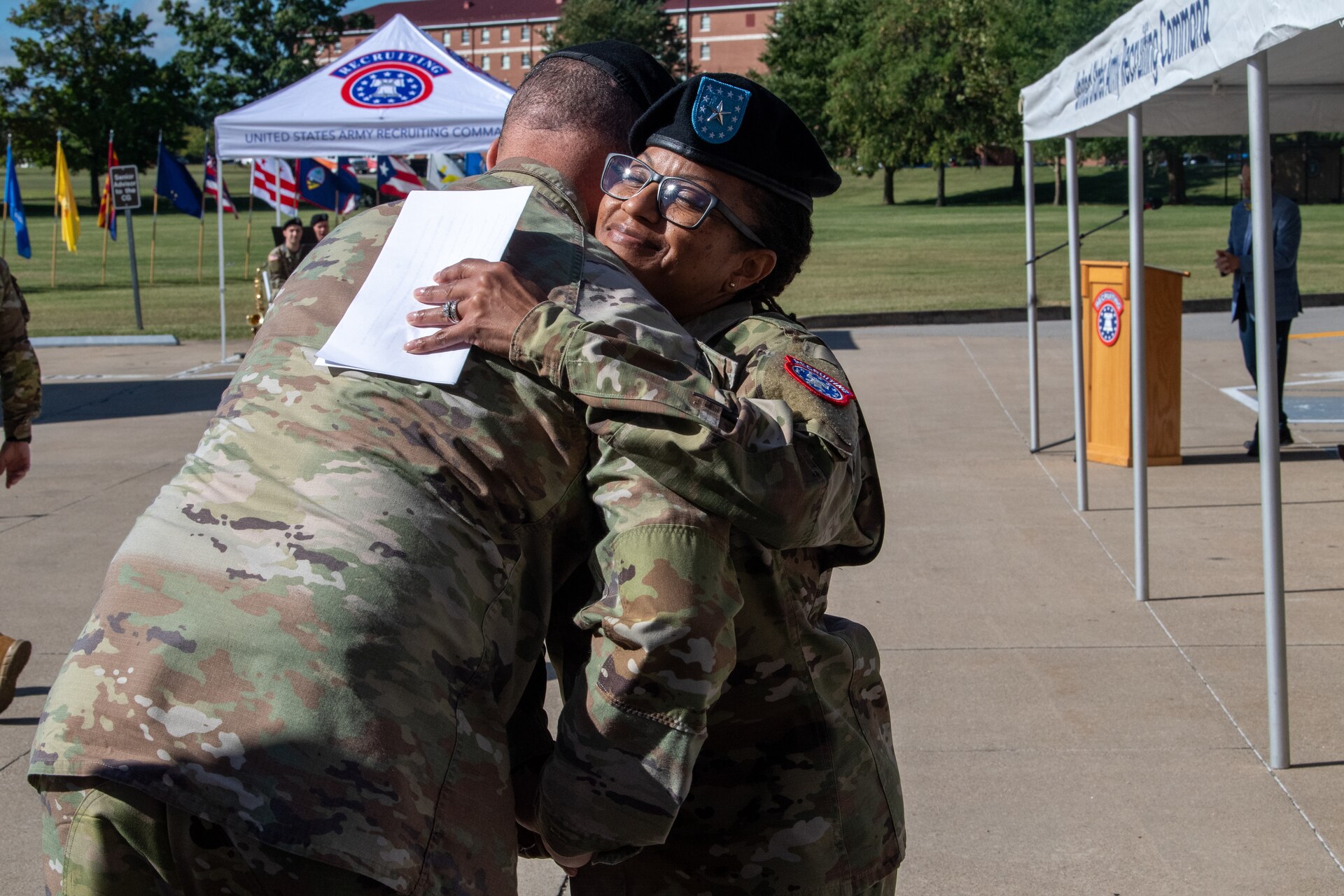 Two Army soldiers embrace in a hug.