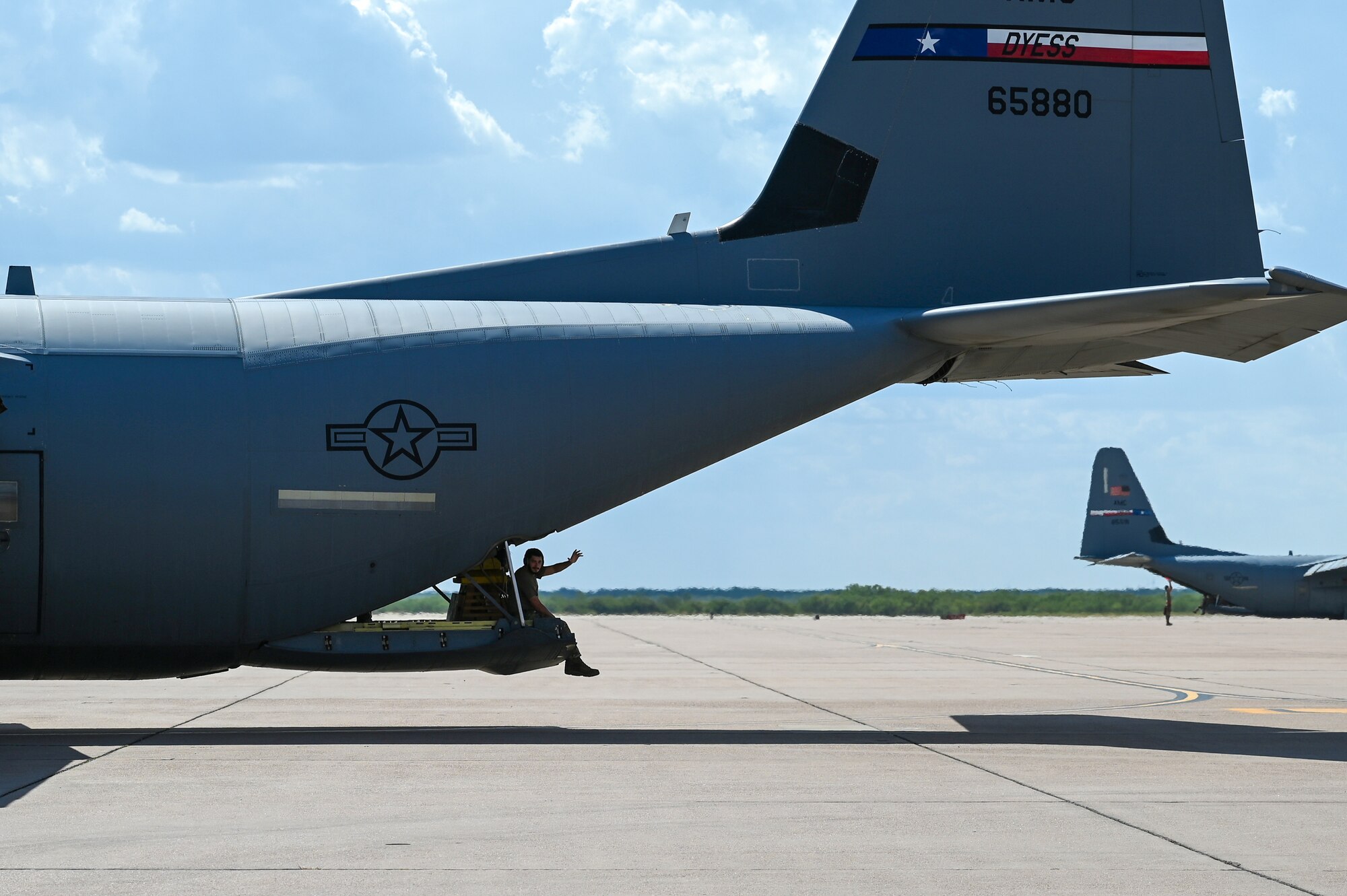 An Airman from the 317th Airlift Wing waves from a C-130J Super Hercules.