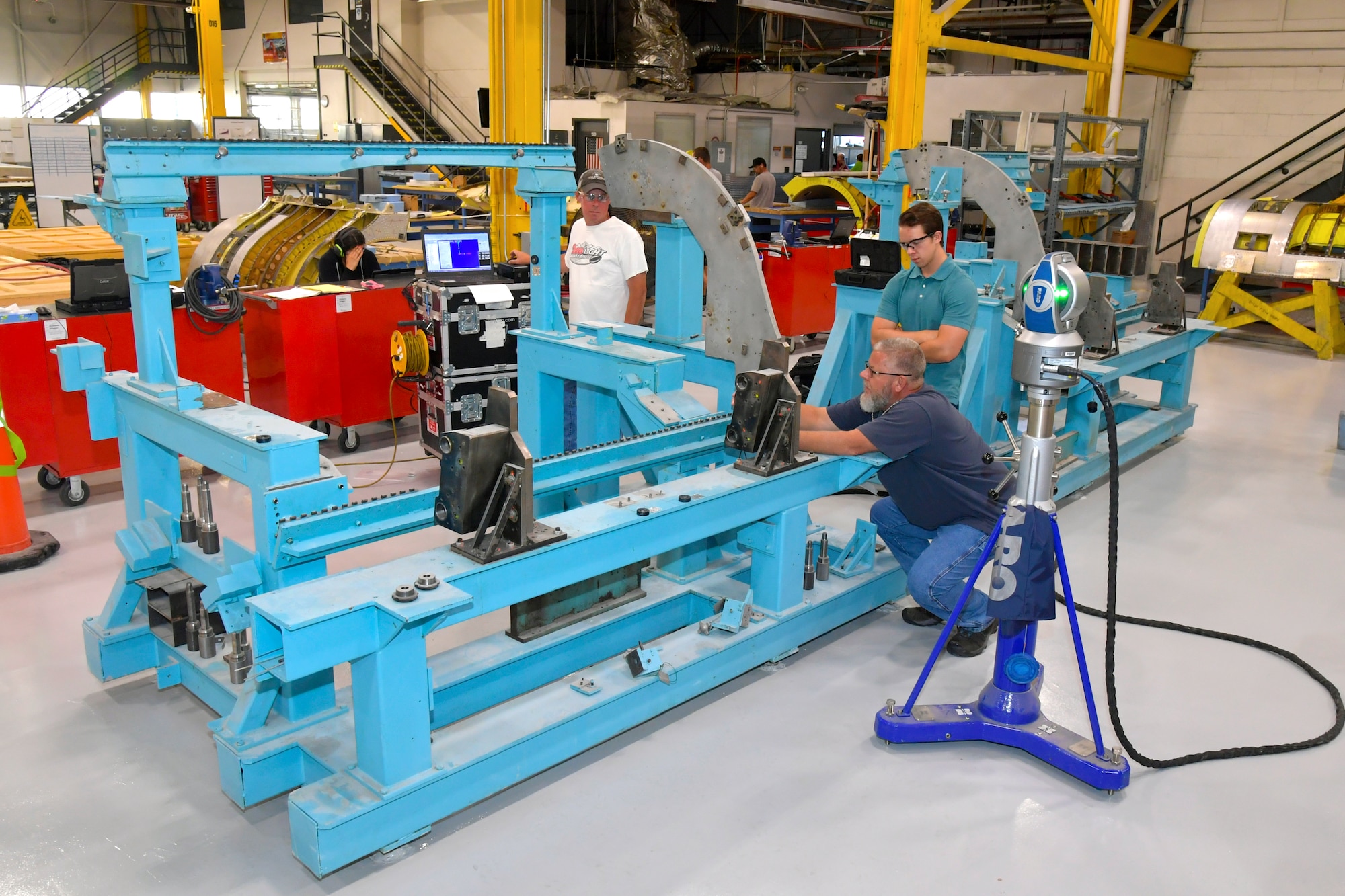 (Right to left) Jay Hudson, Metrology and Calibration Flight technician, and Richard Thompson, MCF summer intern, and Brian Wilson, MCF dimensional work lead, check tolerances on a jig fixture used for building A-10 fuselage sections. Machine inspections and calibrations are accomplished on thousands of machines throughout the installation each year by personnel in the 809th Maintenance Support Squadron. (U.S. Air Force photo by Todd Cromar)