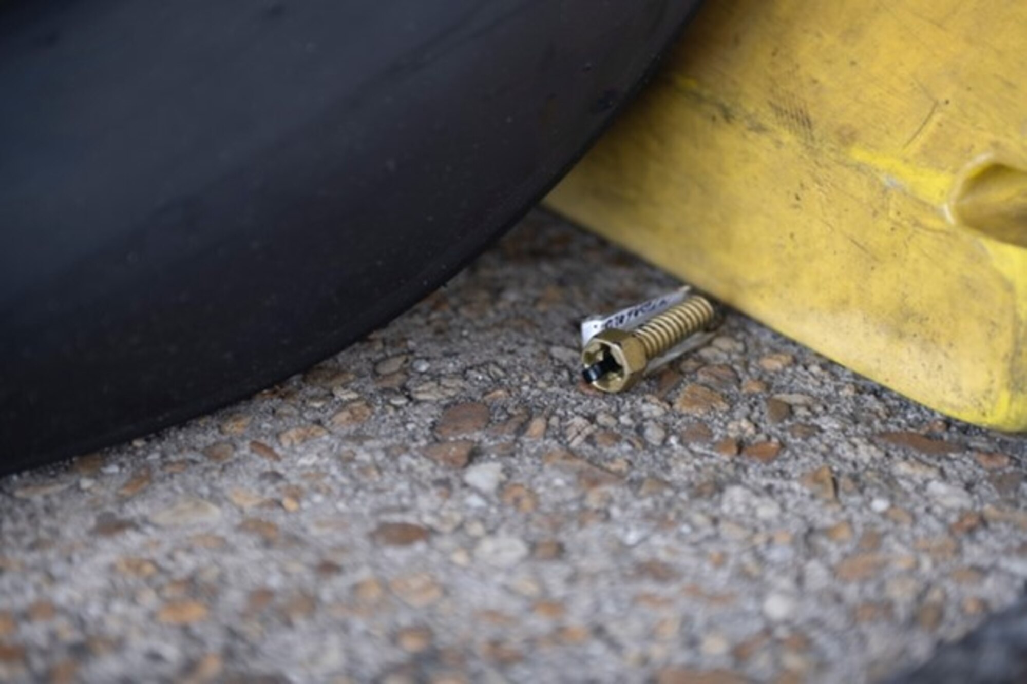 A golden bolt sits near an A-10 tire