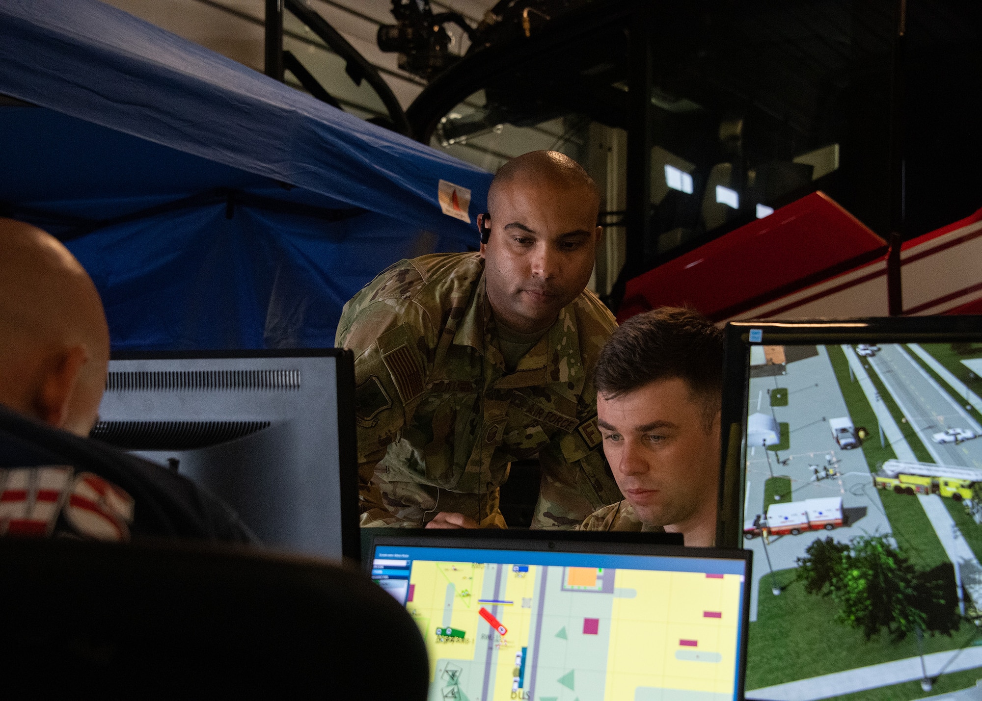 U.S. Air Force Master Sergeant Frank Butler, 316th Wing Inspections superintendent, works with Staff Sergeant William Leuzinger, 316th CES firefighter, on the Advanced Disaster Management Simulator at Joint Base Andrews, Md., Aug. 29, 2023.