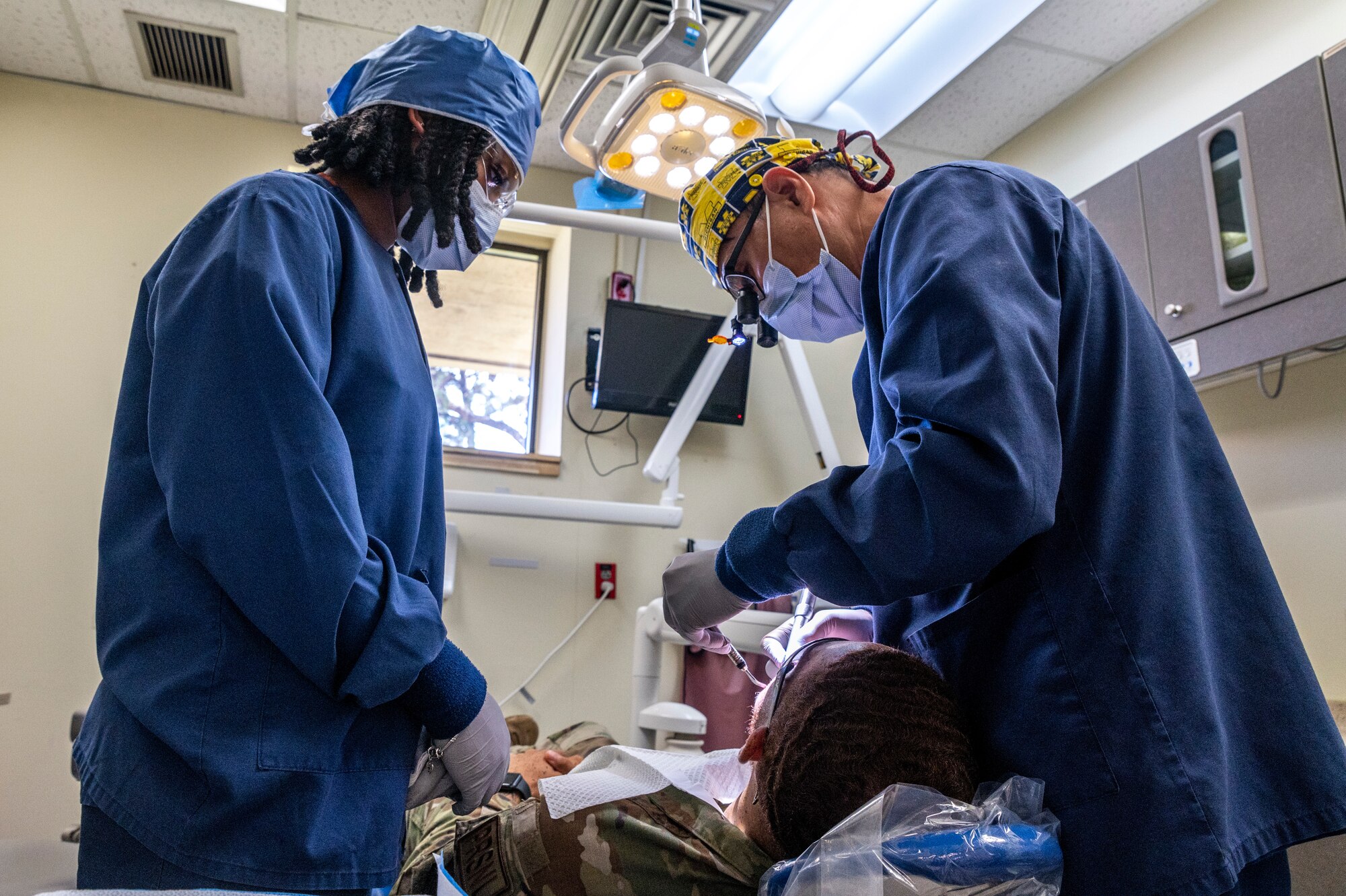 U.S. Air Force Maj. Changeun Song, right, 51st Operational Medical Readiness Squadron dentist, and Senior Airman Alina Brown, 51st OMRS dental assistant, treat a patient at Osan Air Base, Republic of Korea, Sep. 6, 2023.