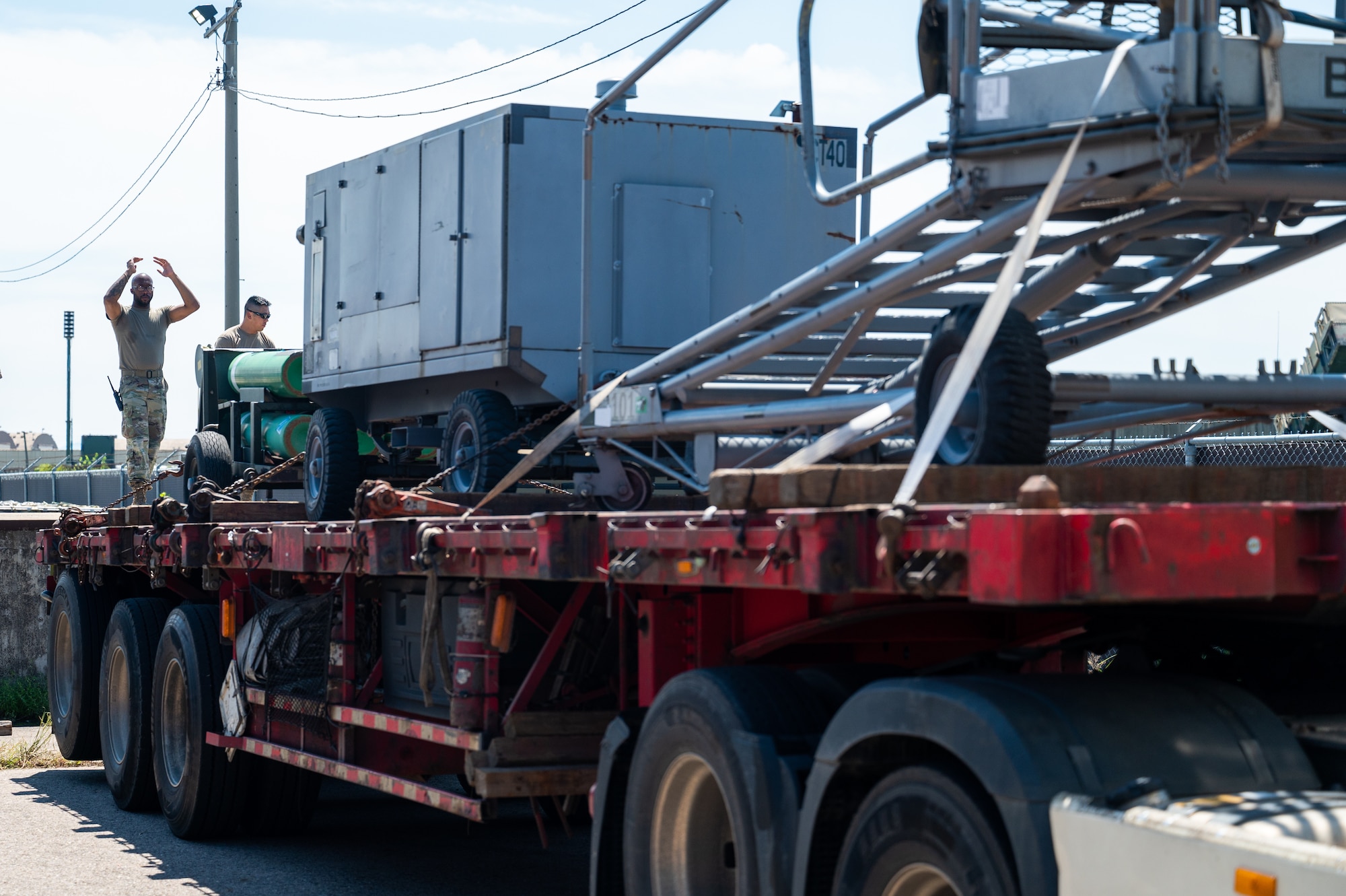 Senior Airman Adam Porter marshals a truck hauling cargo from Operation Pack Up into docking.