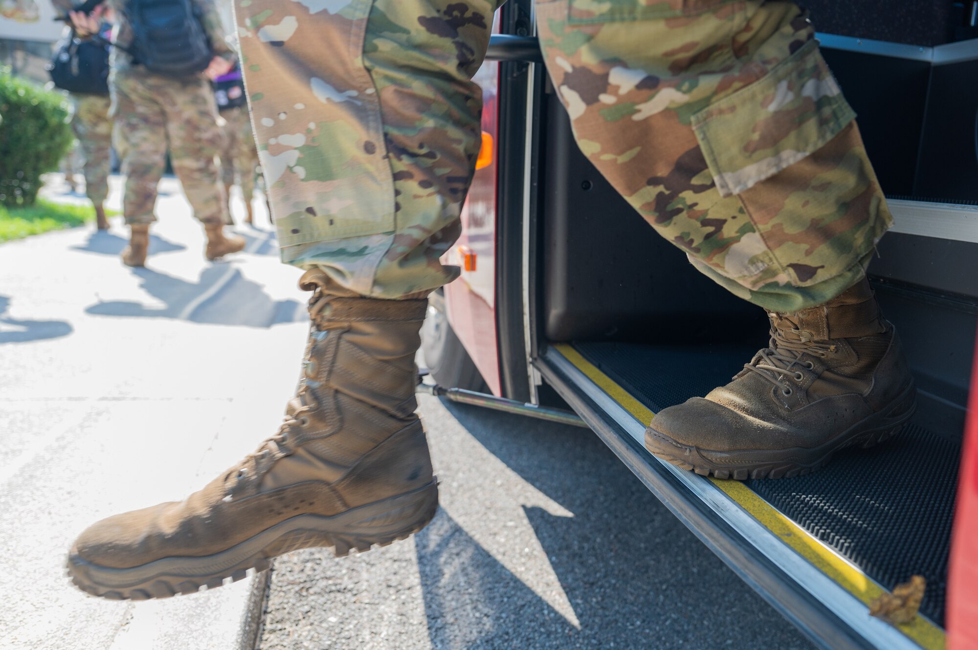 A member of the 8th Operations Group steps off a bus after returning from Operation Pack Up.